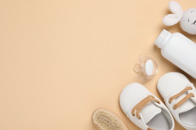 Photo of Flat lay composition with pacifier and other baby stuff on beige background. Space for text