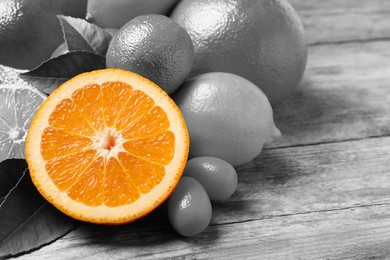 Fresh juicy citrus fruits on wooden table. Black and white tone with selective color effect