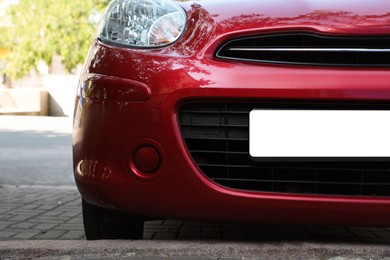 Car with vehicle registration plate outdoors, closeup