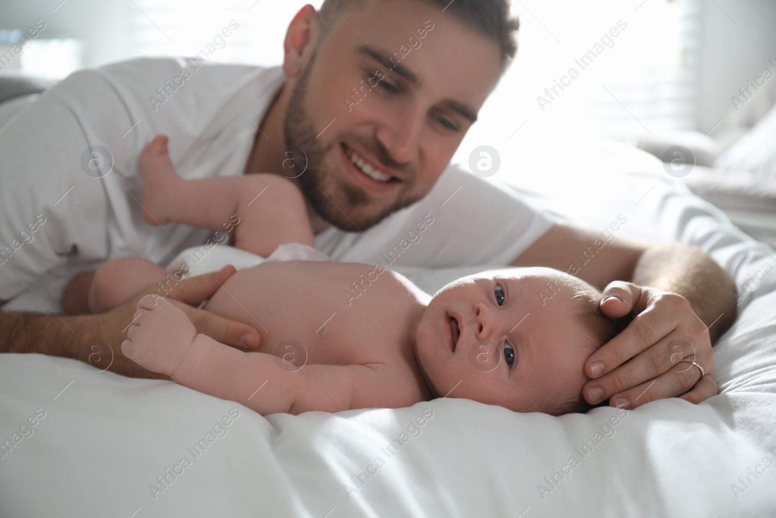 Photo of Father with his newborn son at home