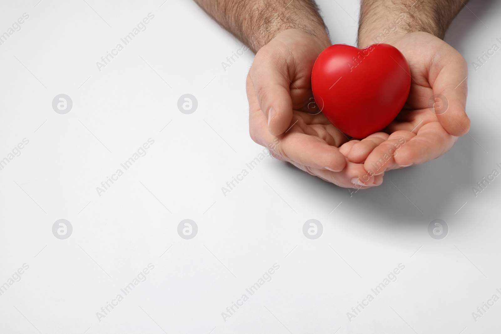 Photo of Man holding red heart on white background, closeup
