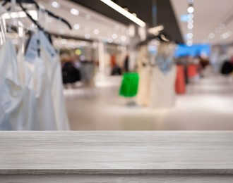 Image of Empty wooden surface and blurred view of clothes store interior. Space for design