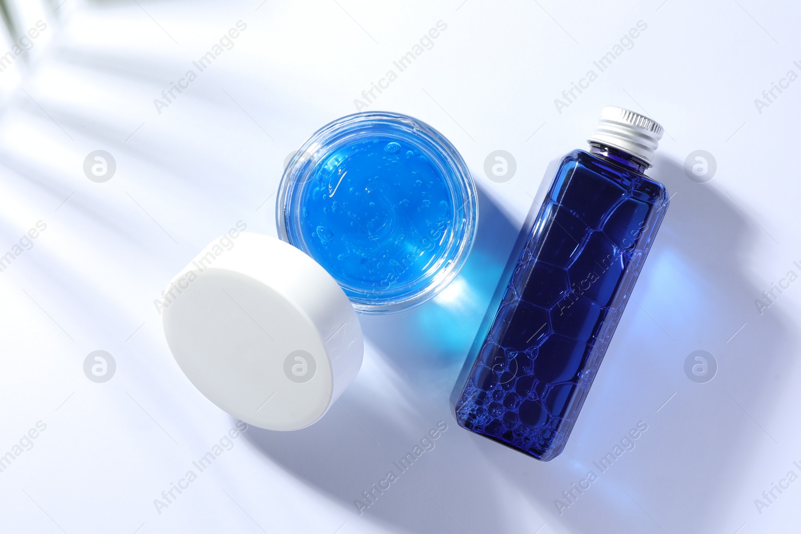 Photo of Bottle and jar of cosmetic products on white background, flat lay