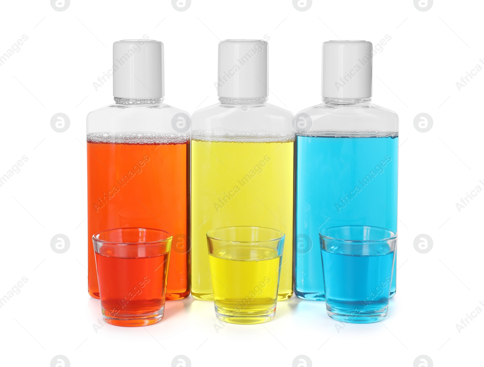 Photo of Bottles and glasses of mouthwash isolated on white