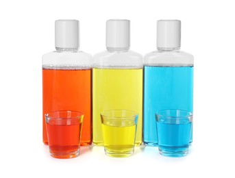 Photo of Bottles and glasses of mouthwash isolated on white