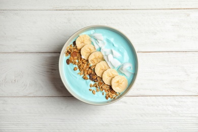 Bowl of spirulina smoothie on wooden background, top view