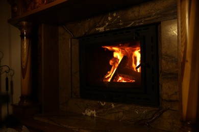Photo of Fireplace with burning wood in darkness at home