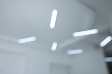 Blurred view of white ceiling with modern lights
