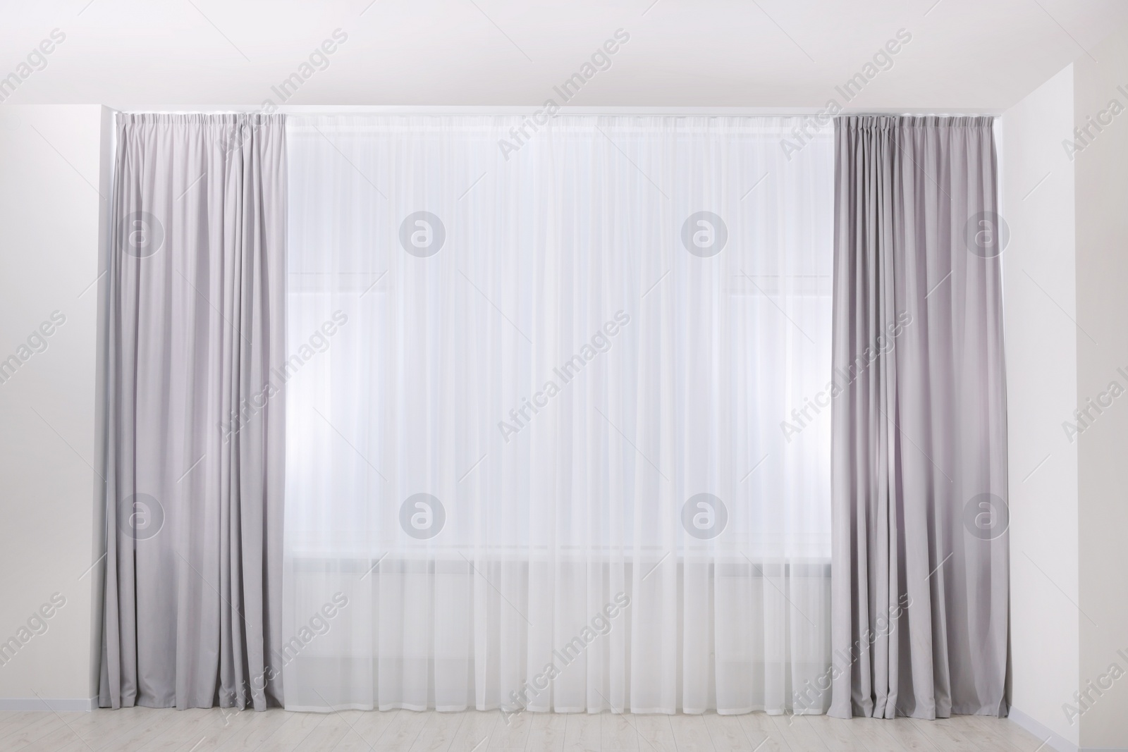 Photo of Light grey window curtains and white tulle indoors