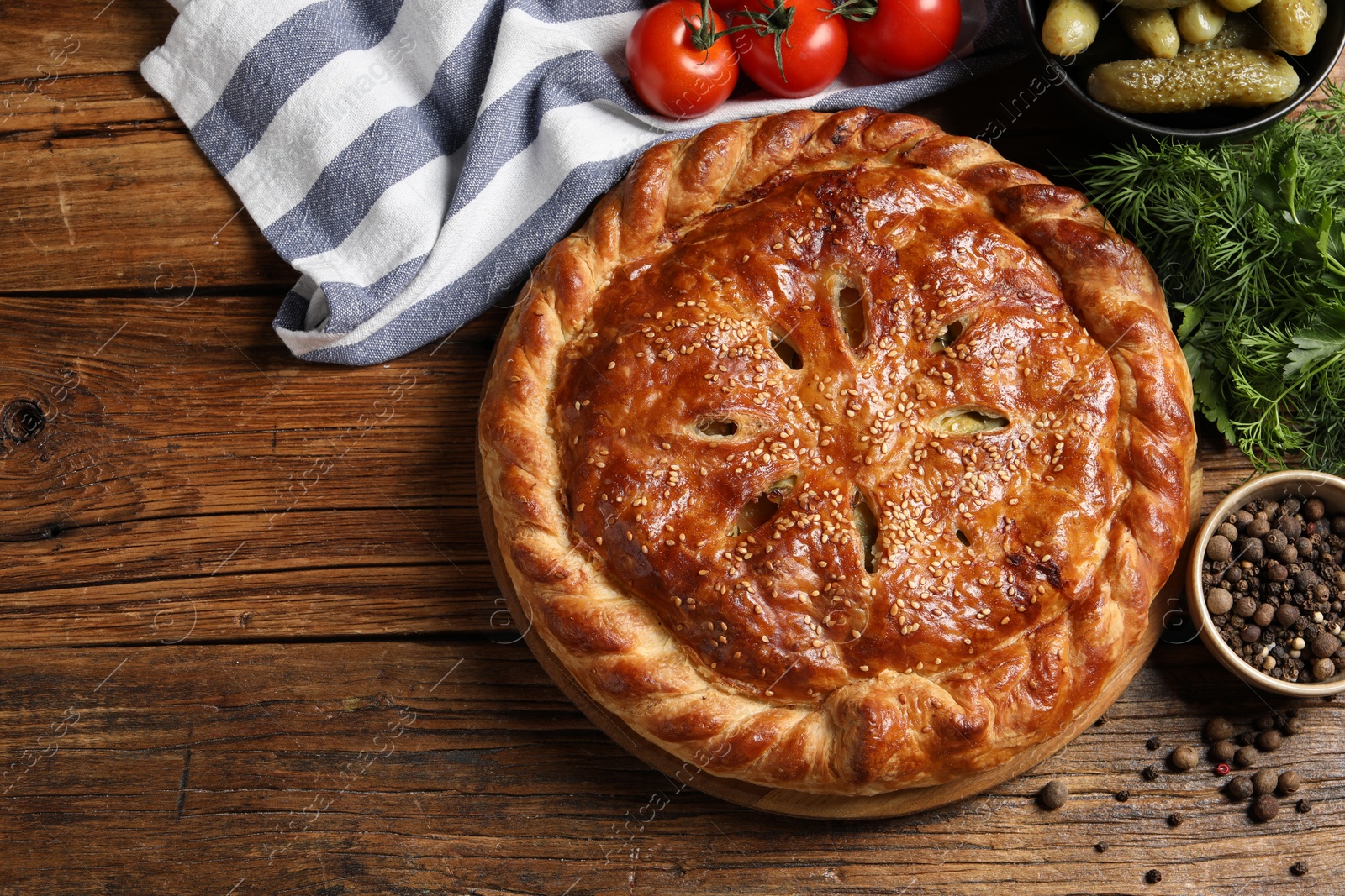 Photo of Tasty homemade pie and ingredients on wooden table, flat lay. Space for text