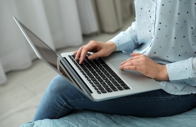 Blogger working with modern laptop at home, closeup