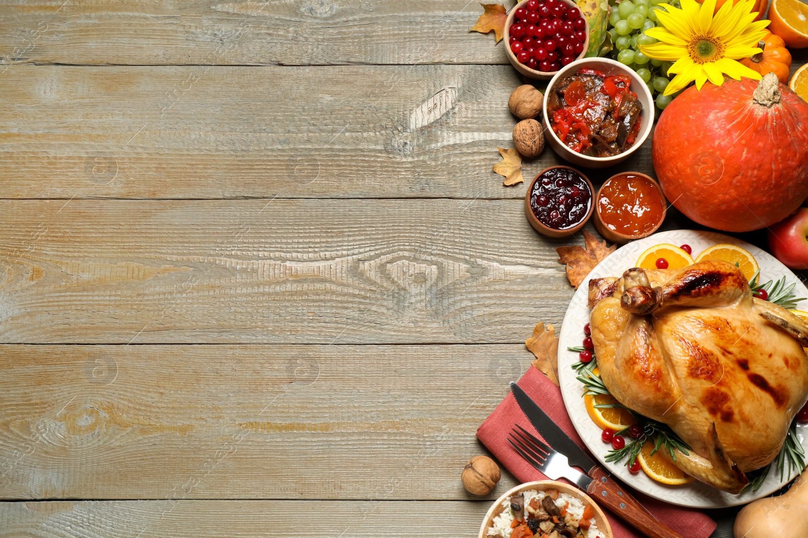 Photo of Traditional Thanksgiving day feast with delicious cooked turkey and other seasonal dishes served on wooden table, flat lay. Space for text