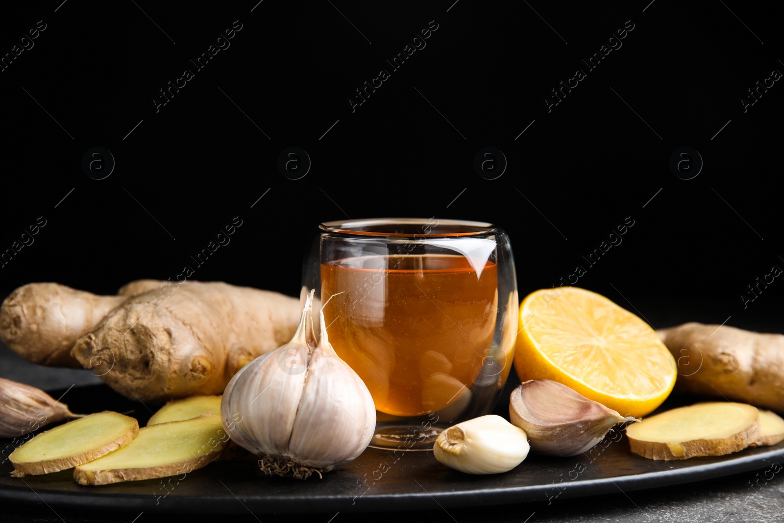 Photo of Fresh garlic and other natural cold remedies on grey table