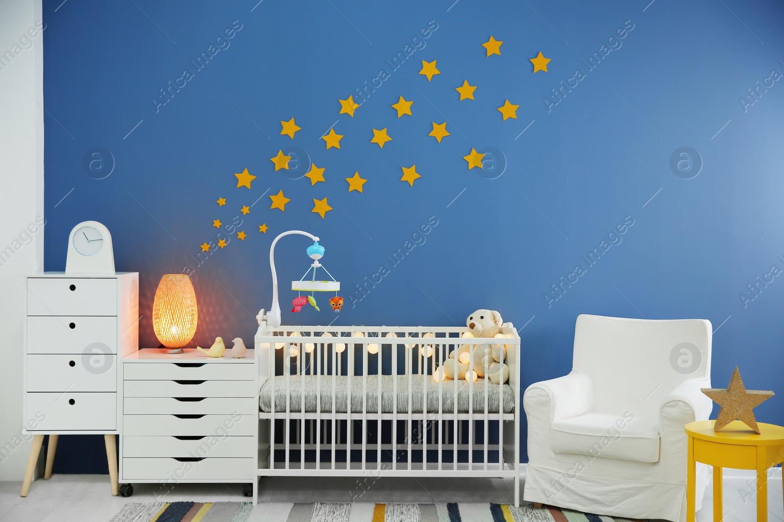 Photo of Baby room interior with comfortable crib and armchair