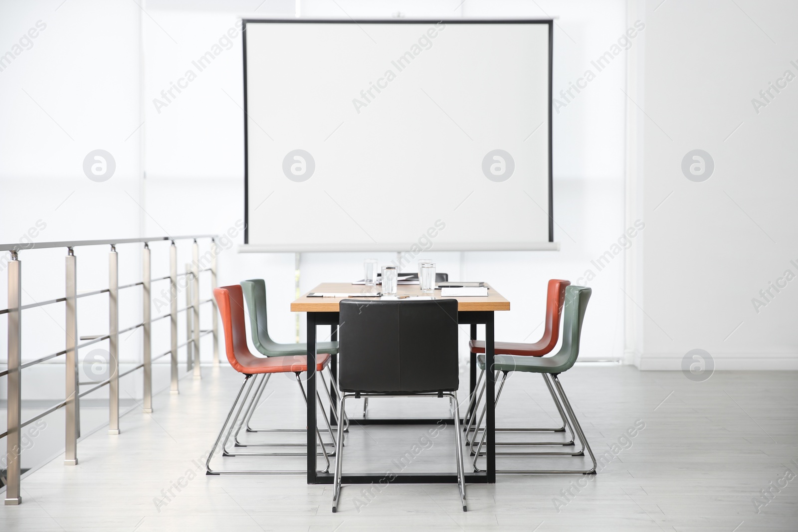 Photo of Modern meeting room interior with large table and projection screen