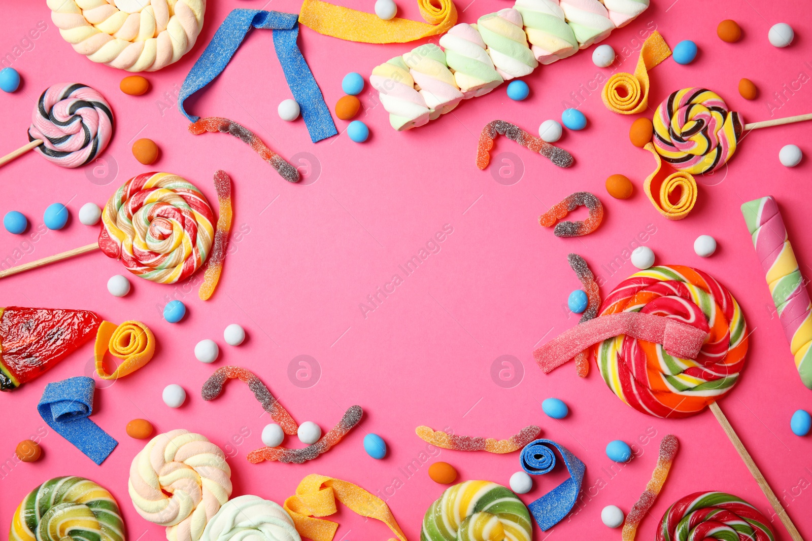 Photo of Flat lay composition with different yummy candies and space for text on color background