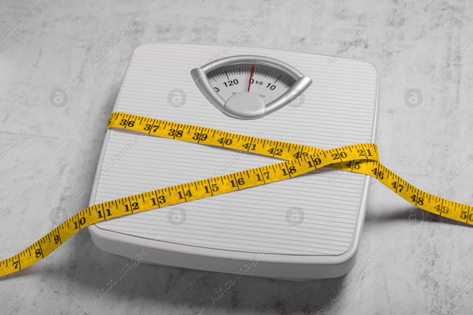 Photo of Scales and measuring tape on grey textured background. Weight loss concept