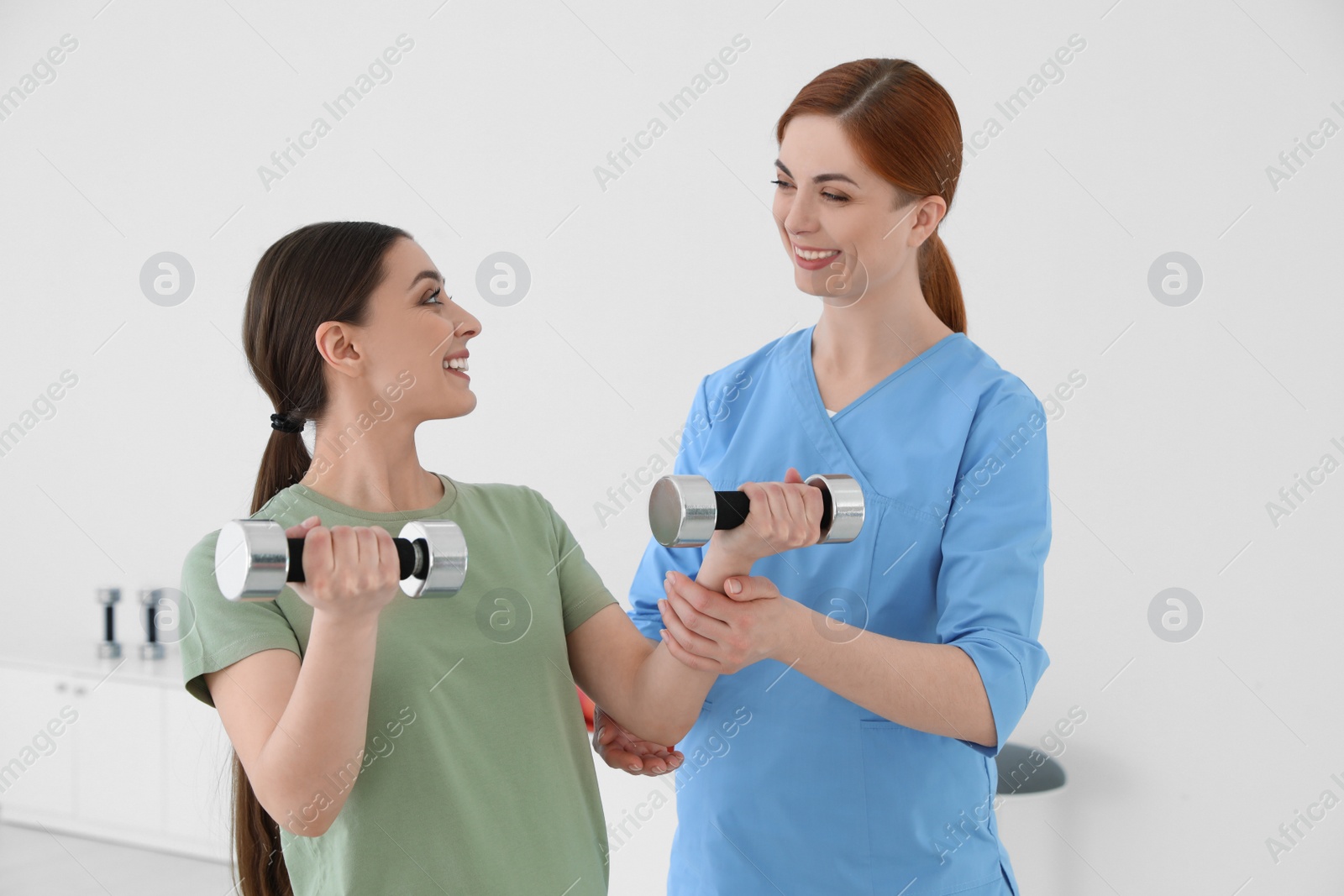 Photo of Professional physiotherapist working with female patient in rehabilitation center