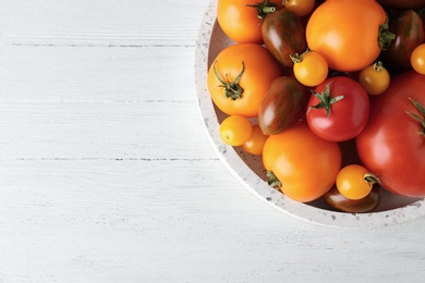 Fresh ripe tomatoes on white wooden table, top view. Space for text