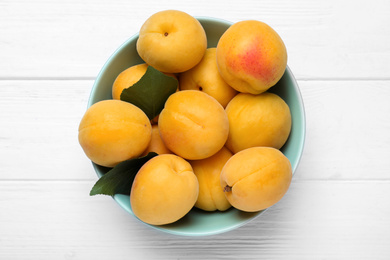 Delicious fresh ripe apricots on white wooden table, top view