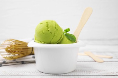 Photo of Tasty matcha ice cream in bowl on white wooden table