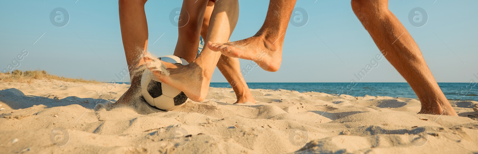 Image of Group of friends playing football on sandy beach, closeup. Banner design