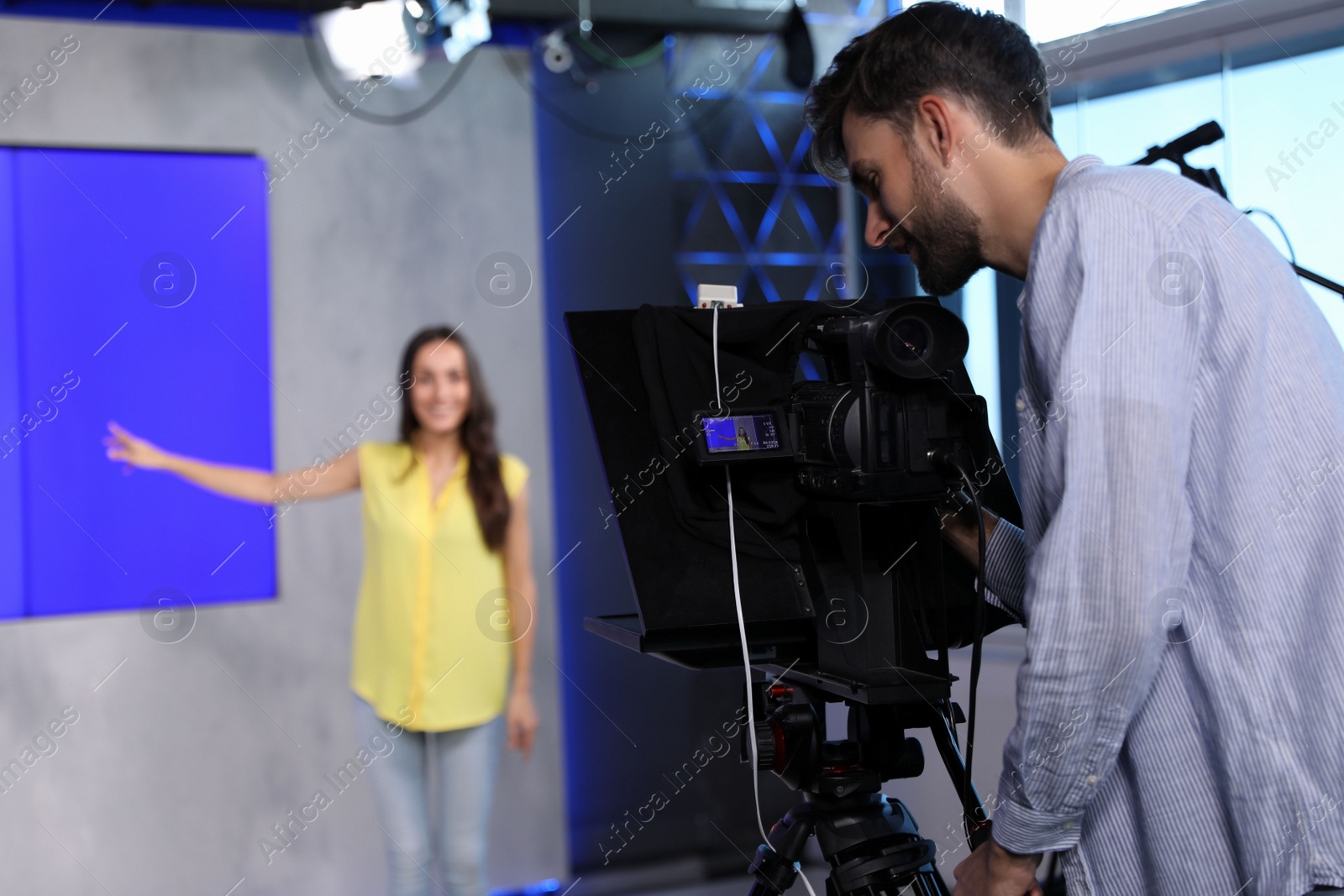 Photo of Professional video camera operator and presenter working in studio