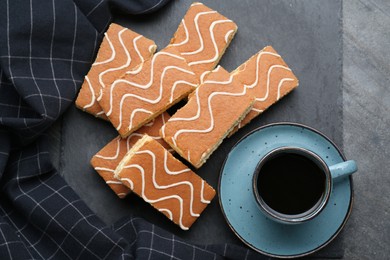 Tasty sponge cakes and hot drink on grey table, flat lay