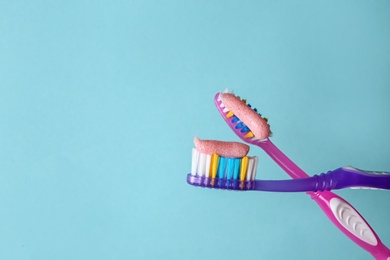 Photo of Toothbrushes with paste on color background, closeup