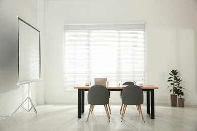 Photo of Conference room interior with wooden table and video projection screen