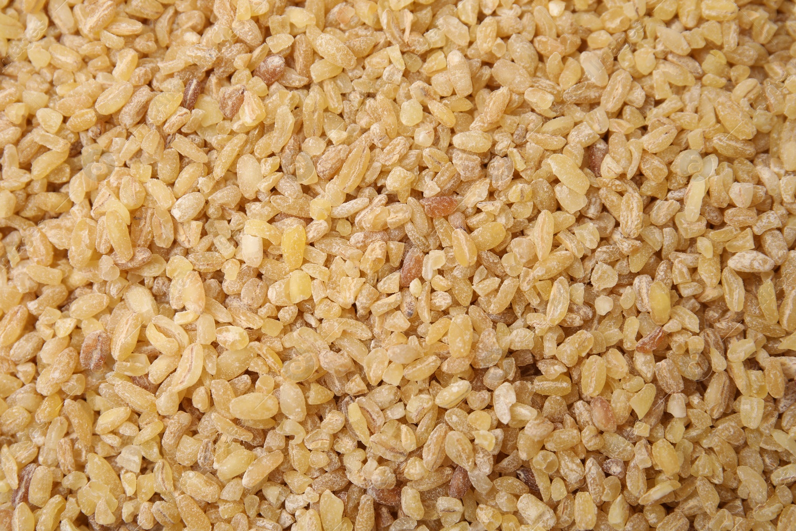 Photo of Uncooked organic bulgur as background, top view