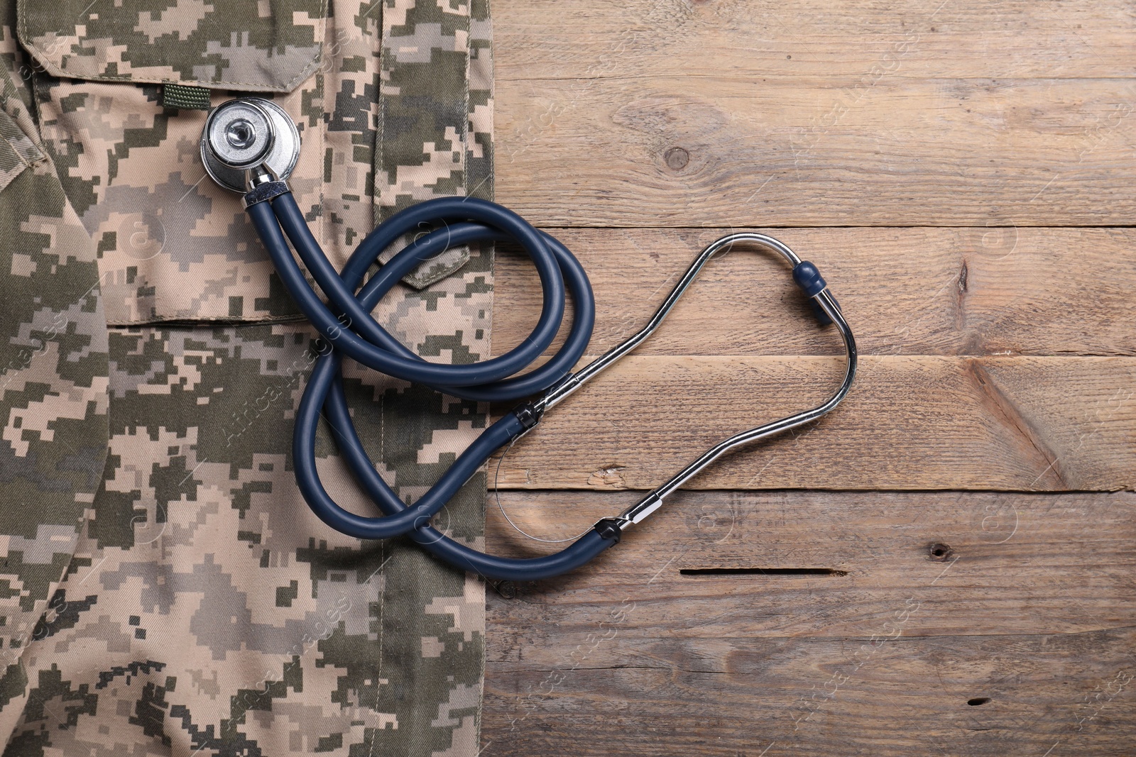Photo of Stethoscope and military uniform on wooden background, flat lay