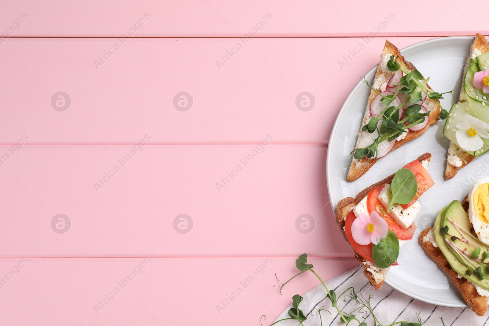 Photo of Different tasty sandwiches served on pink wooden table, flat lay. Space for text