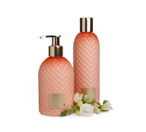Stylish bottles with cosmetic products and flowers on white background
