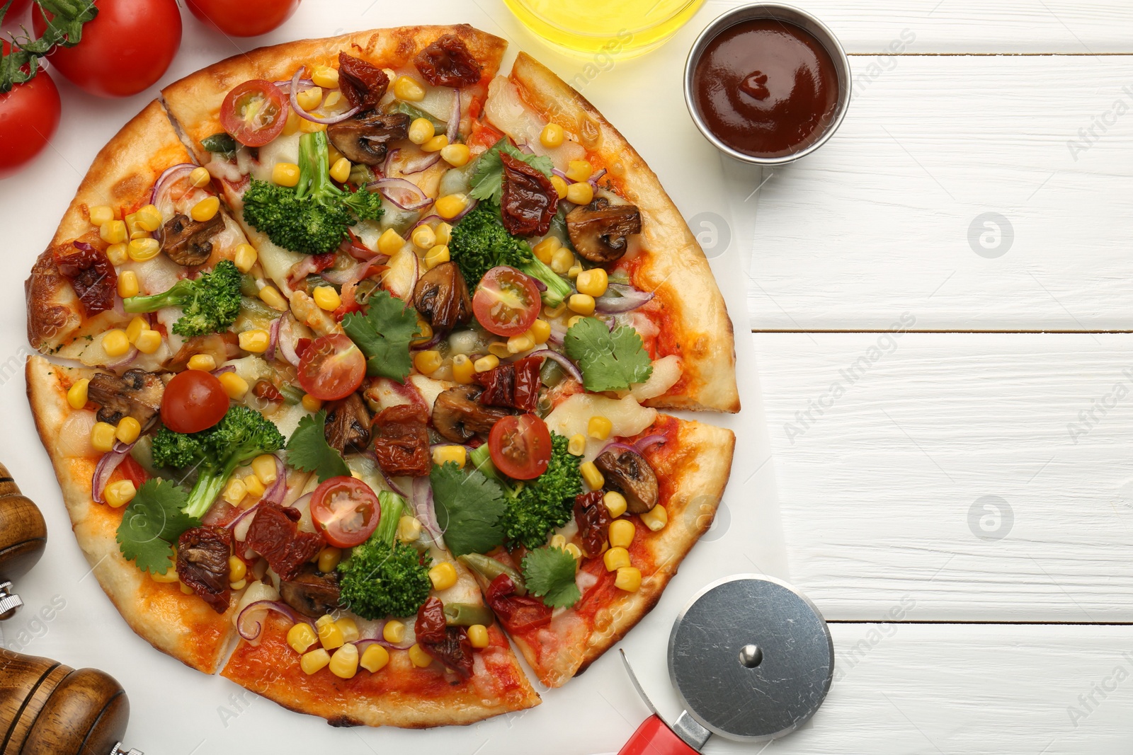 Photo of Delicious vegetarian pizza served on white wooden table, flat lay. Space for text