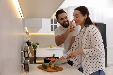 Photo of Happy lovely couple cooking together in kitchen