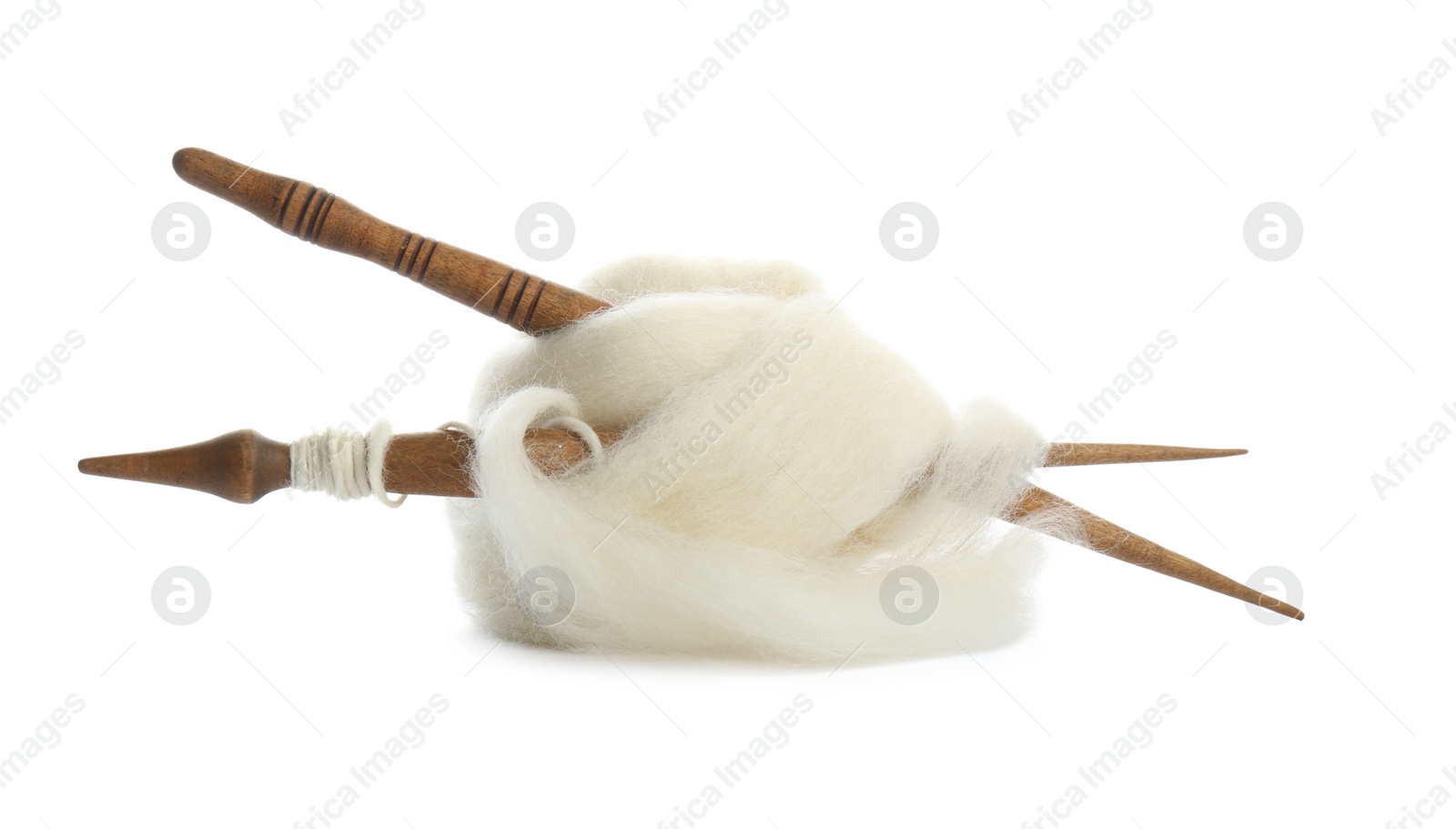 Photo of Ball of combed wool with different wooden spindles isolated on white