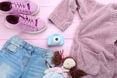 Flat lay composition with little photographer's toy camera on pink wooden background