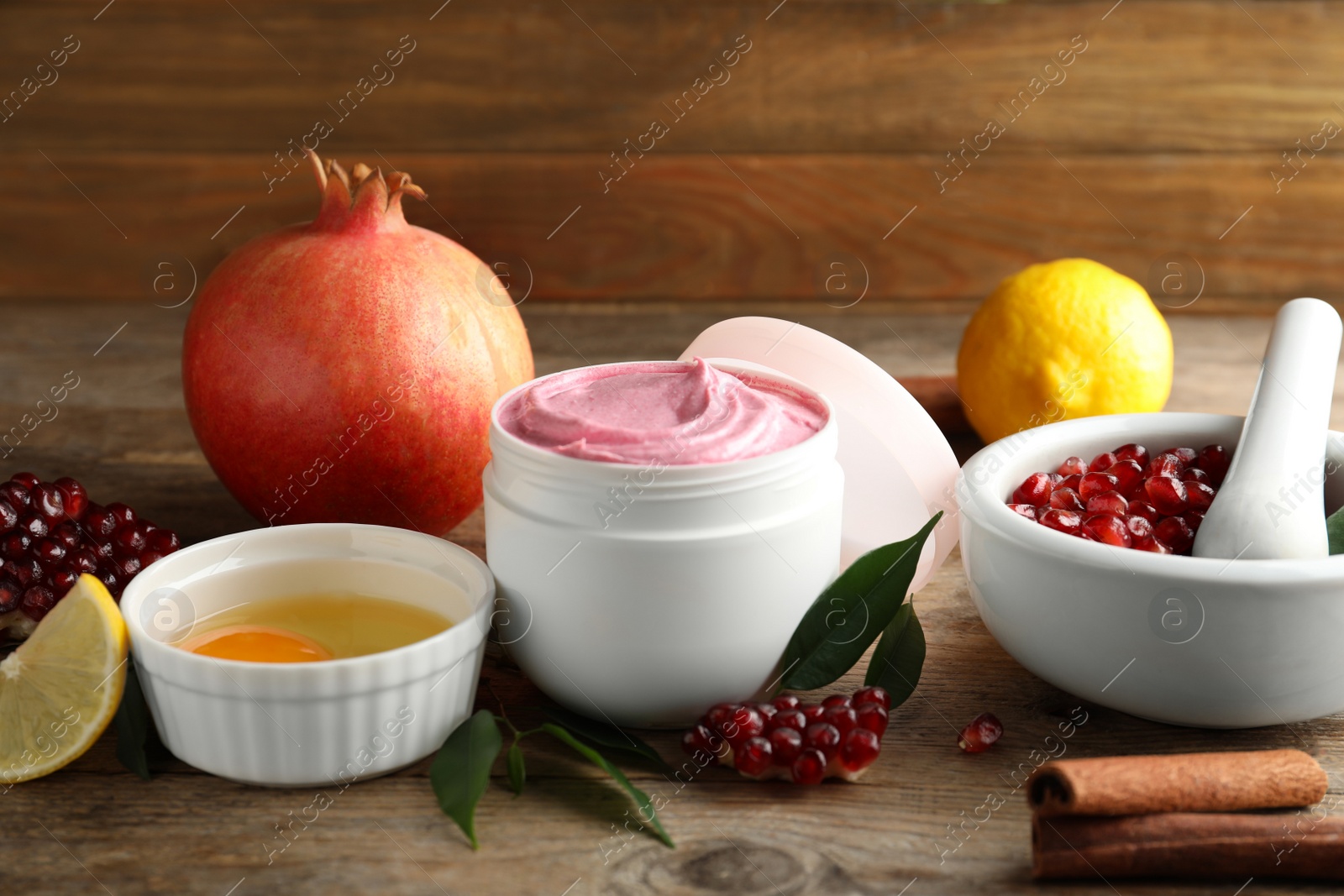 Photo of Natural homemade mask, pomegranate and ingredients on wooden table