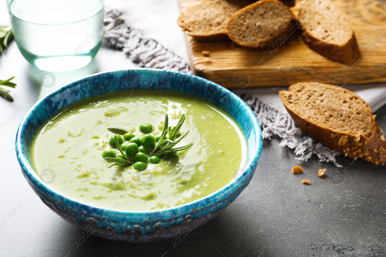 Photo of Fresh vegetable detox soup made of green peas in dish served on table. Space for text