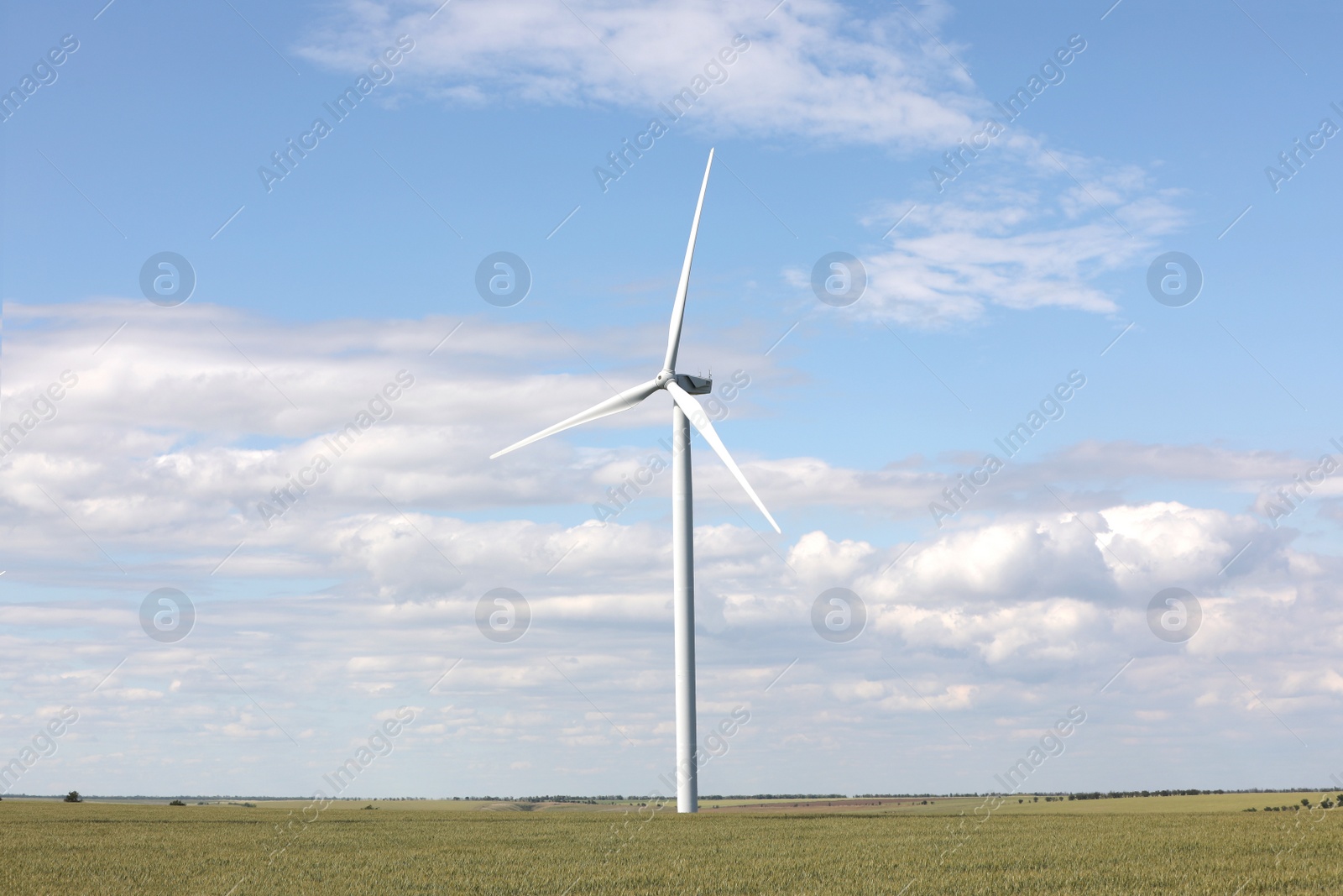 Photo of Beautiful view of field with wind turbine. Alternative energy source