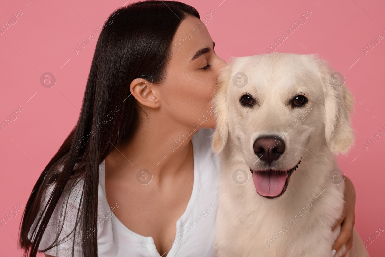 Photo of Woman with cute Labrador Retriever dog on pink background. Adorable pet