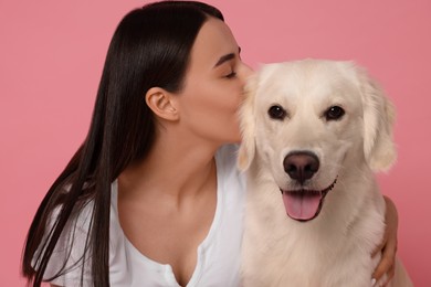 Woman with cute Labrador Retriever dog on pink background. Adorable pet
