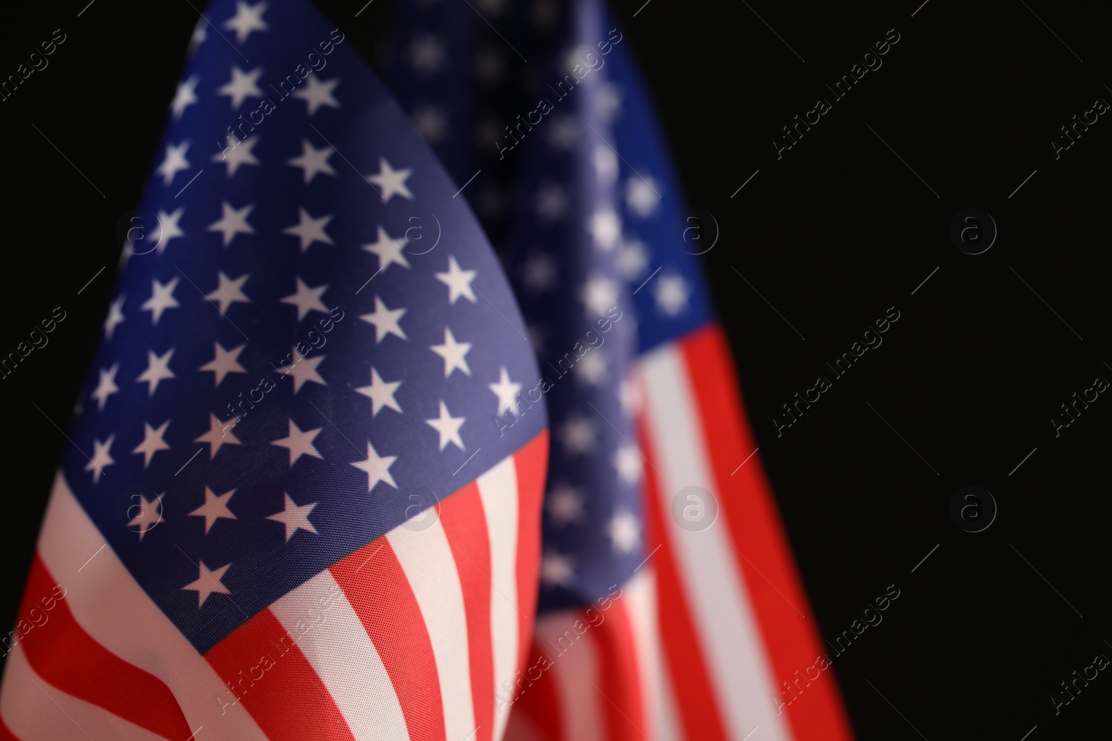 Photo of National flags of America on black background, space for text. Memorial day celebration
