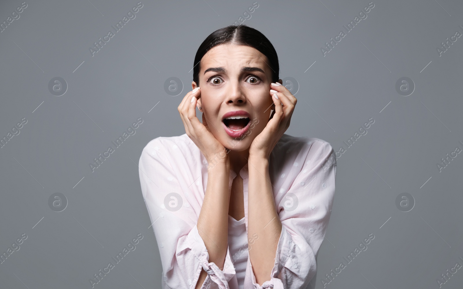 Photo of Young woman feeling fear on grey background