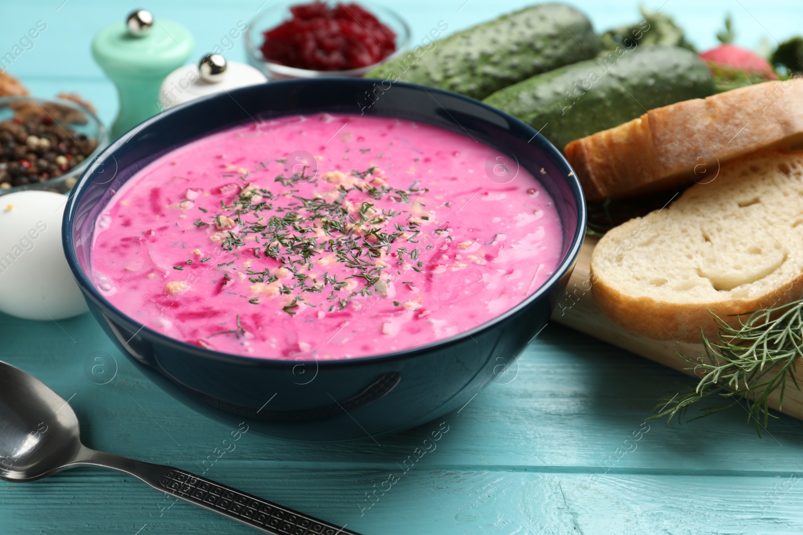 Photo of Delicious cold summer beet soup on light blue wooden table