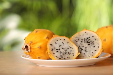 Delicious cut and whole dragon fruits (pitahaya) on wooden table, closeup