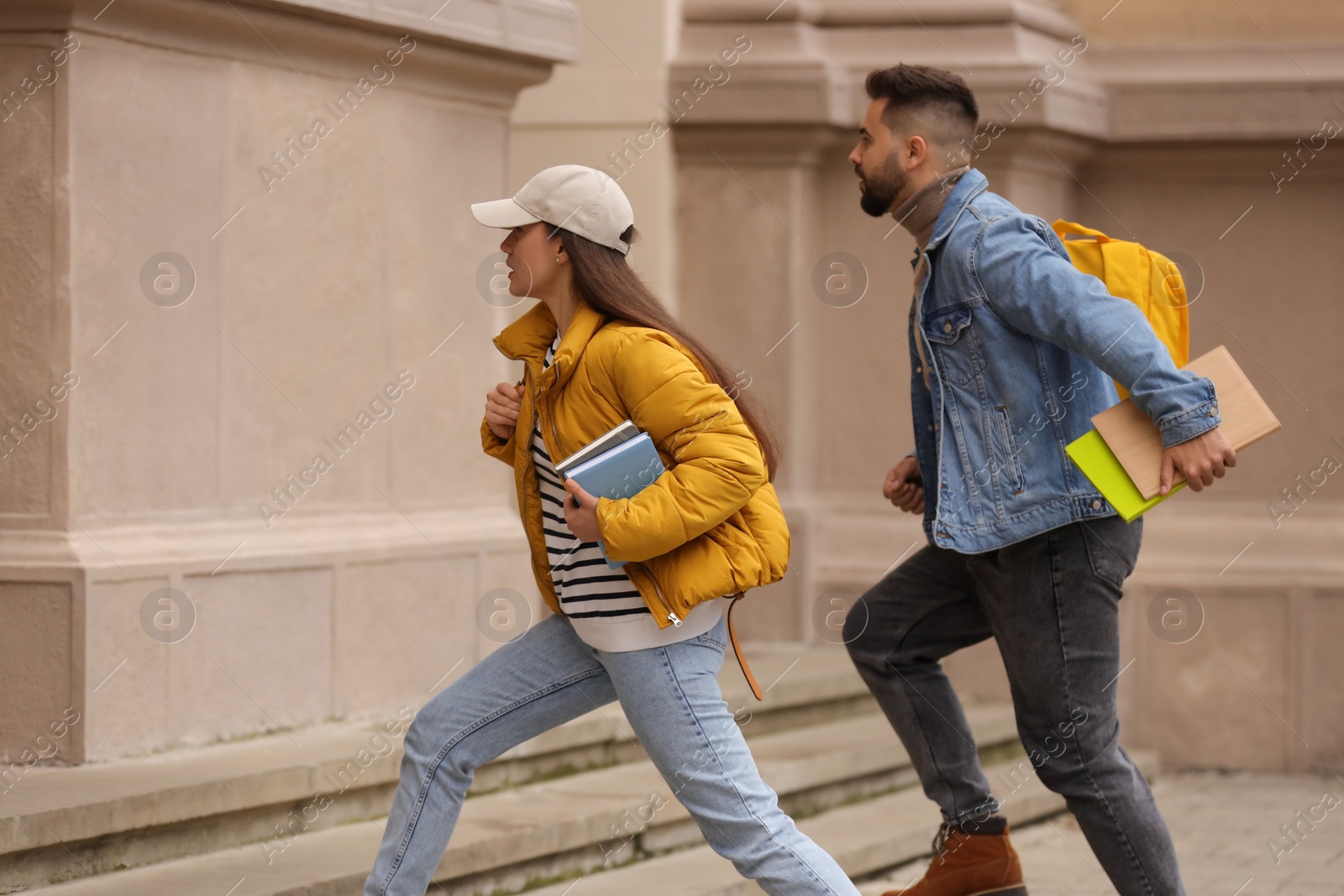 Photo of Being late. Students running towards building outdoors, space for text