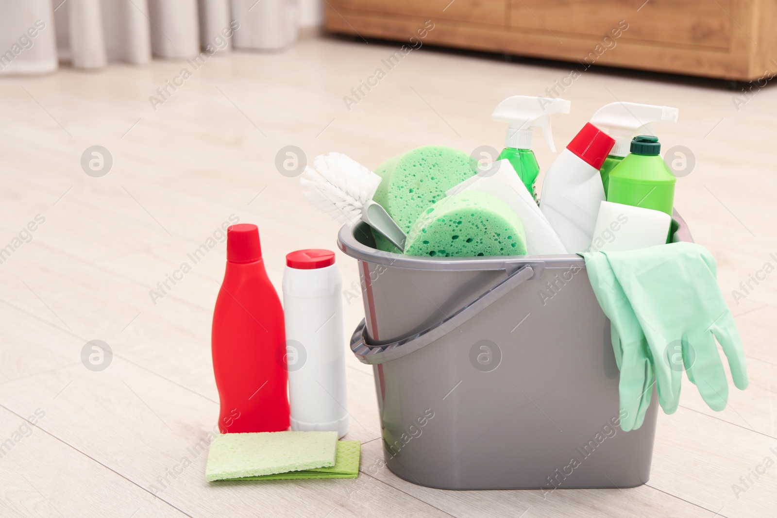 Photo of Different cleaning supplies in bucket on floor