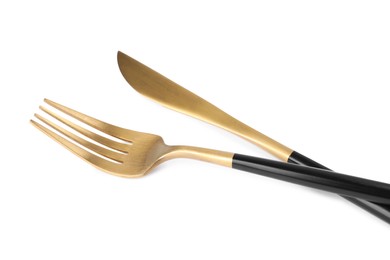 New golden fork and knife with black handles on white background